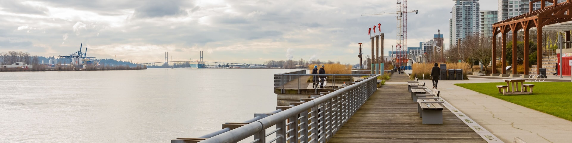 Pier and walkway by riverside. Beautiful river park in New Westminster in overcast day.