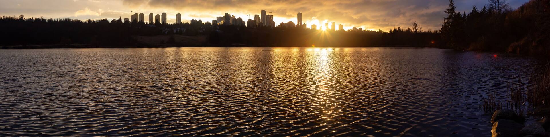 Burnaby, Greater Vancouver, British Columbia, Canada. Beautiful Panoramic View of Deer Lake during a colorful and vibrant winter sunset with Metrotown Buildings in the Background. Panorama