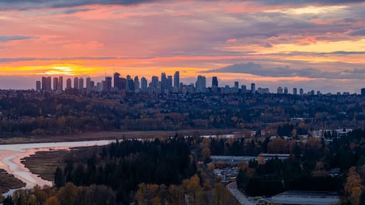 Sunset Over Burnaby Skyline With River, Forest, And City Lights In Greater Vancouver, BC, Canada