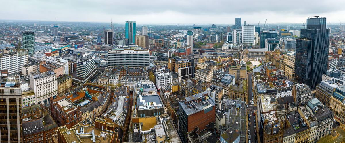 A densely packed cityscape with a mix of modern and historic buildings, including a prominent tower and several skyscrapers.
