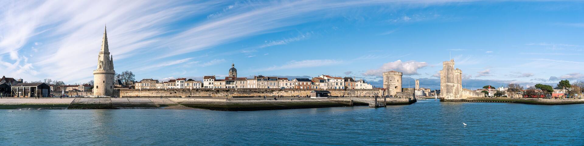 Panoramic view of the old harbor of La Rochelle with old towers on a sunny day