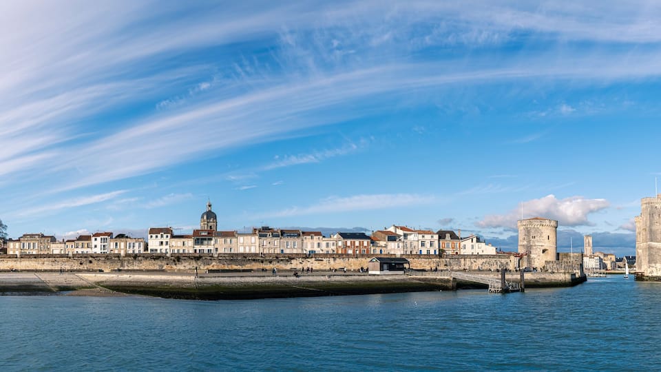 Panoramic view of the old harbor of La Rochelle with old towers on a sunny day