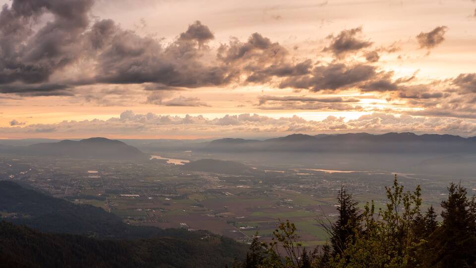 Beautiful Panoramic View of Fraser Valley during a colorful cloudy sunset. Taken from Elk Mountain in Chilliwack, East of Vancouver, British Columbia, Canada. Nature Landscape Panorama Background