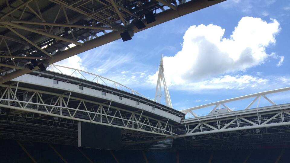 Ein großes Stadion mit einem grünen Rasen und roten Sitzplätzen.