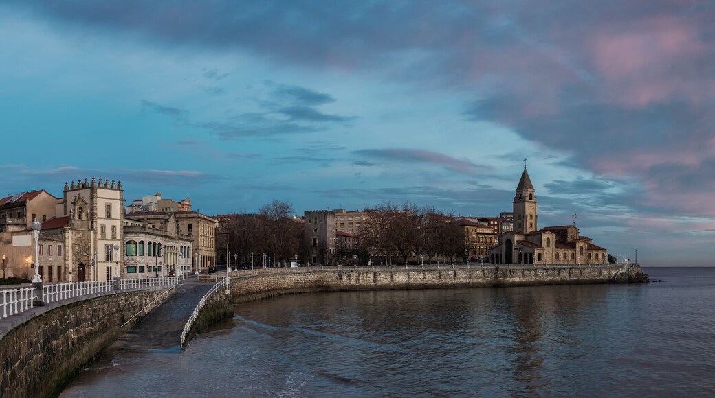 San Pedro church in San Lorenzo beach in Gijon in Asturias natural paradise travel touristic destination for vacations in Spain at dawn before sunrise. Panorama with calm sea landscape background.