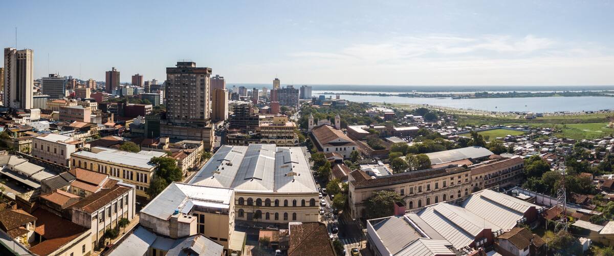 Panoramic view of skyscrapers skyline of Latin American capital of Asuncion city, Paraguay. Embankment of Paraguay river. Birds eye aerial drone photo. Ciudad de Asunción Paraguay.