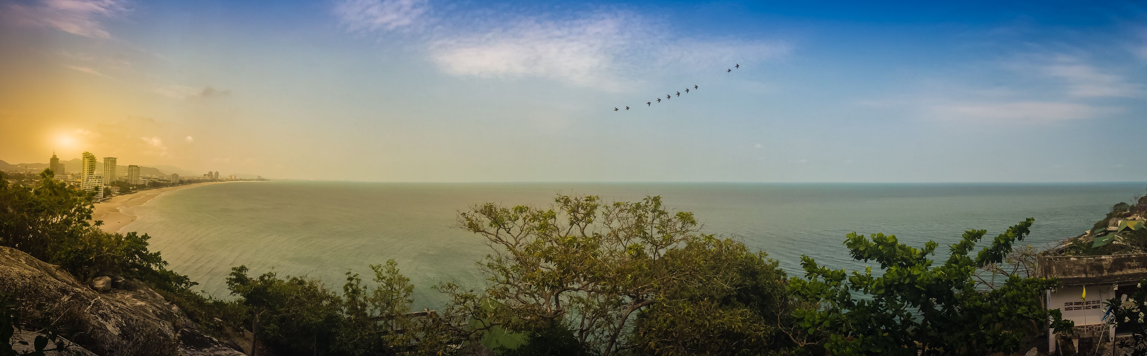 Hua Hin panorama view including sandy beach, green mountain, landscape, cityscape, cloudscape, blue sky scape and seascape in Hua Hin beach, Prachuab Khiri Khan, Thailand.