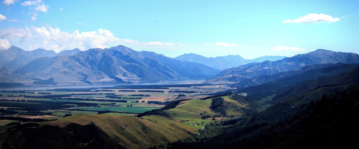 Un paysage montagneux avec une vallée et un lac.
