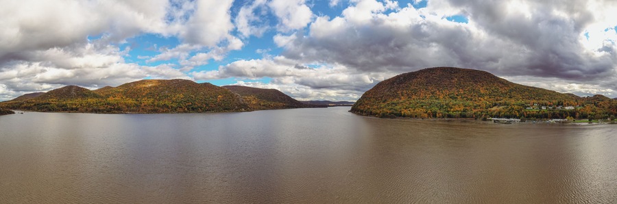 Panoramic view of the Hudson River with autumnal foliage around the mountains at Highland Falls