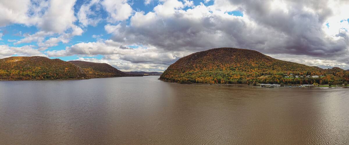 A lake surrounded by hills with autumn foliage.