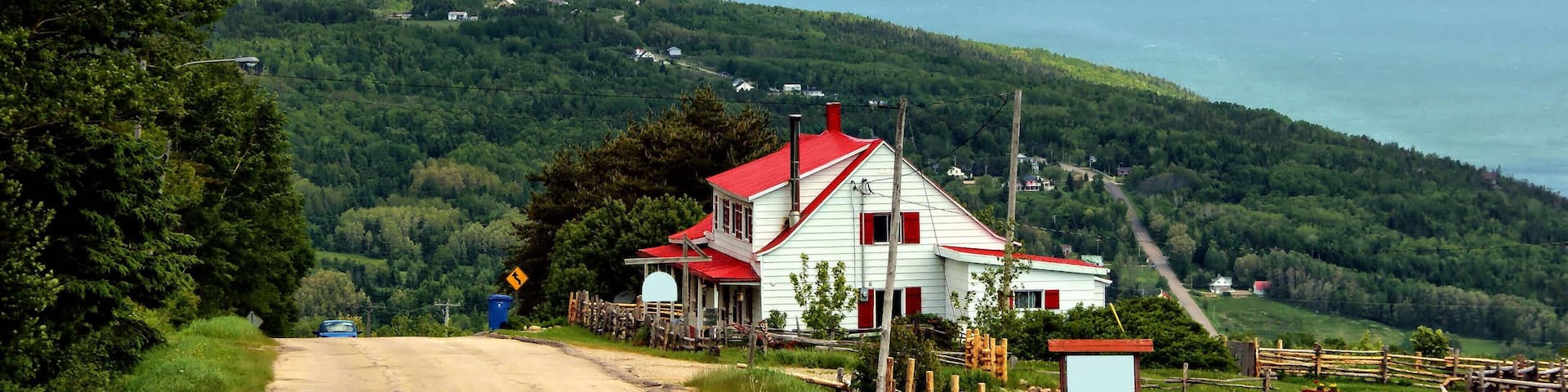 Red house on top of the Mountain and Landscape of La Malbaie Quebec Canada in Background
