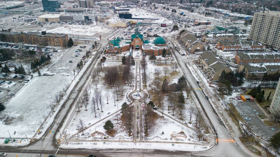 An aerial view of a city with a large central plaza, surrounded by buildings and roads.