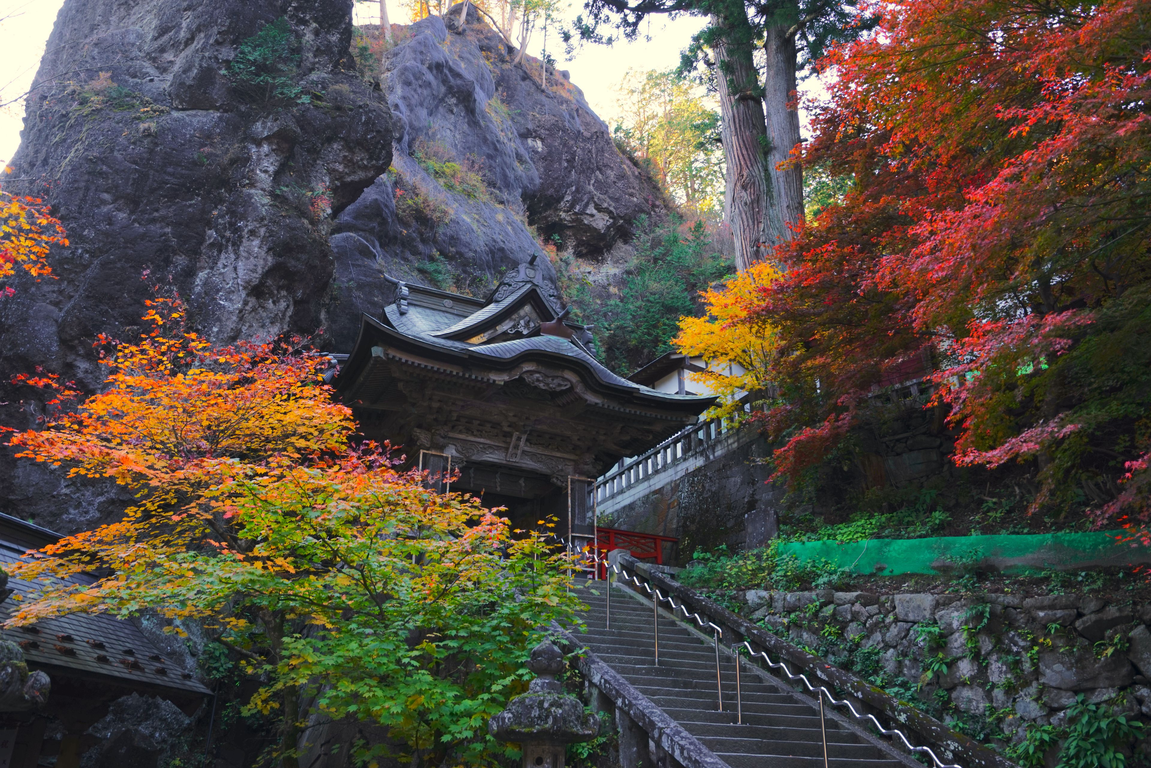 Een traditionele Japanse tempel met een stenen trap die naar een houten gebouw leidt.
