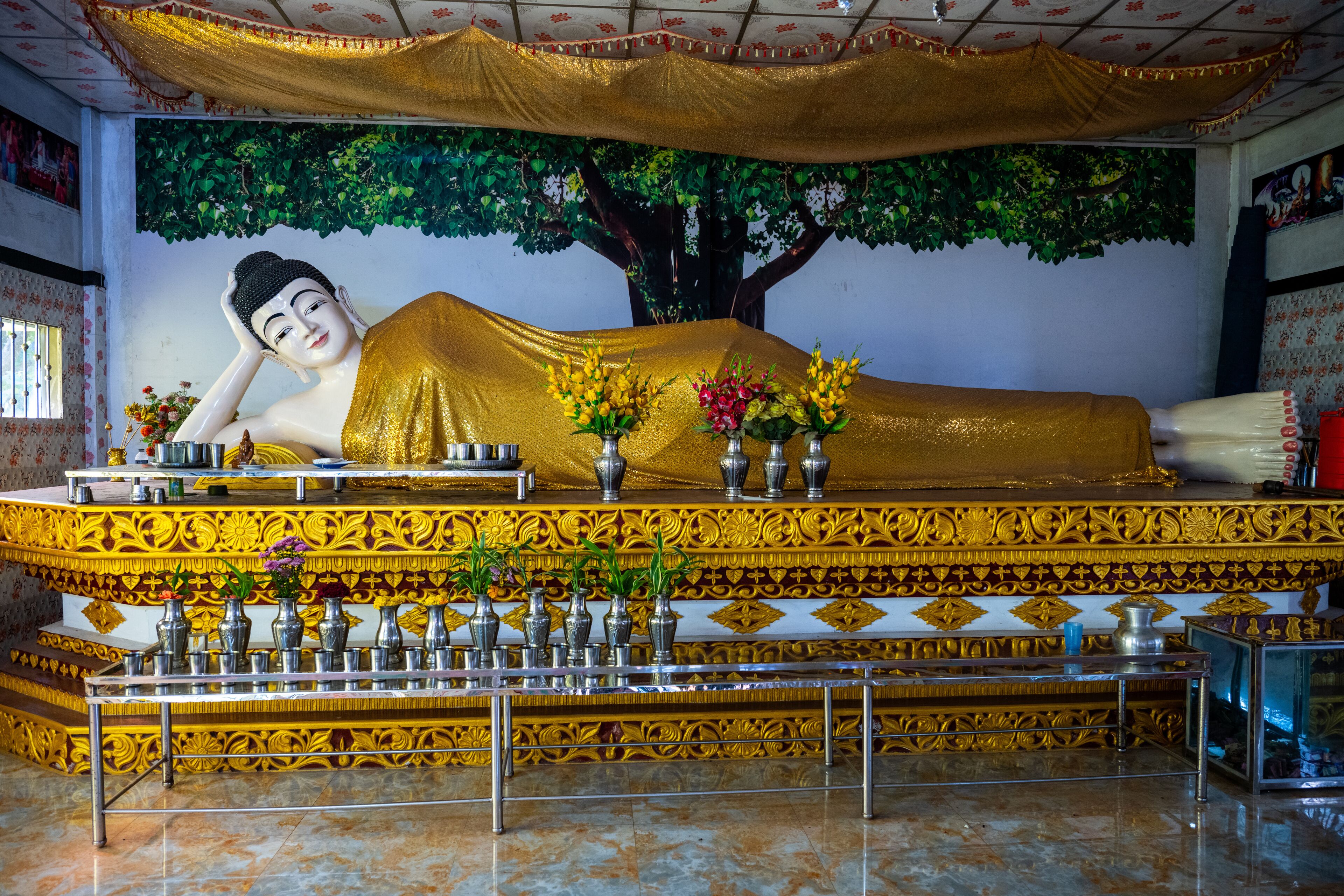 Golden Reclining Buddha Statue Adorned with Flowers at a Buddhist Monastery in Moheskhali Upazila, Cox's Bazar, Bangladesh