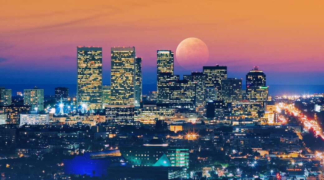 Ful moon rising over Los Angeles skyline at night