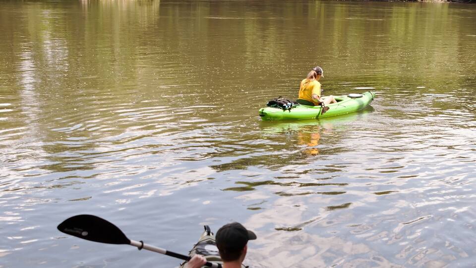 A man and woman in kayaks entering the Allegheny River in Warren county Pennsylvania, USA on a summer day