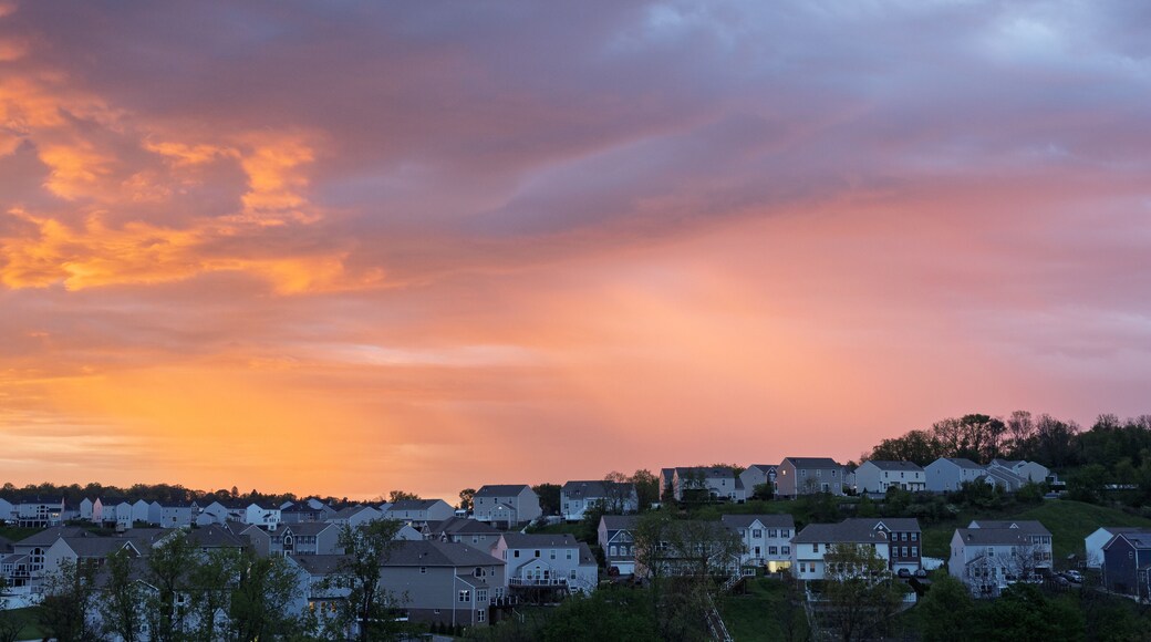 Vivid sunrise colors illuminate clouds over suburban houses outside Pittsburgh
