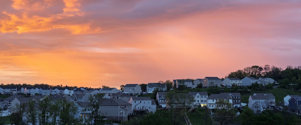 Vivid sunrise colors illuminate clouds over suburban houses outside Pittsburgh
