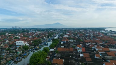 Aerial view of mt slamet in cilacap, indonesia, capturing Cilacap houses, boats on the river, and the majestic mountain. Perfect for travel ads and tourism websites.