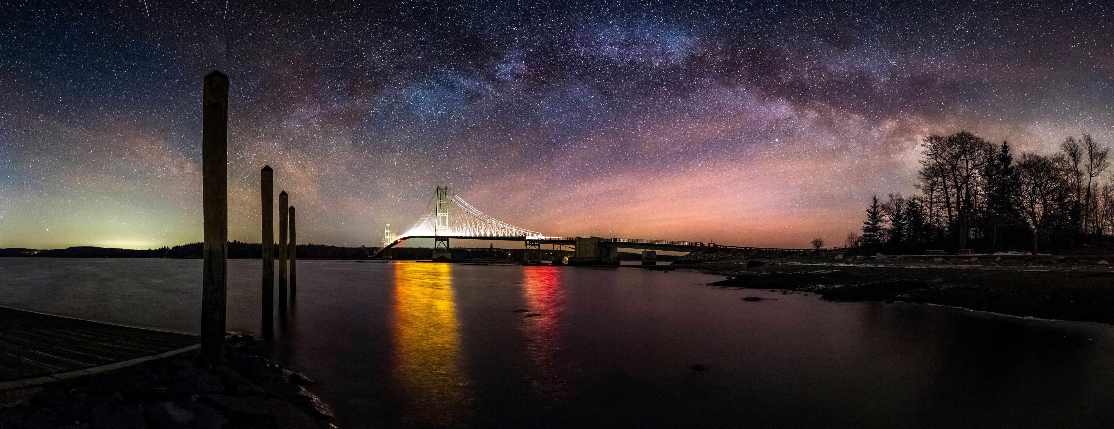 Milky way over illuminated bridge