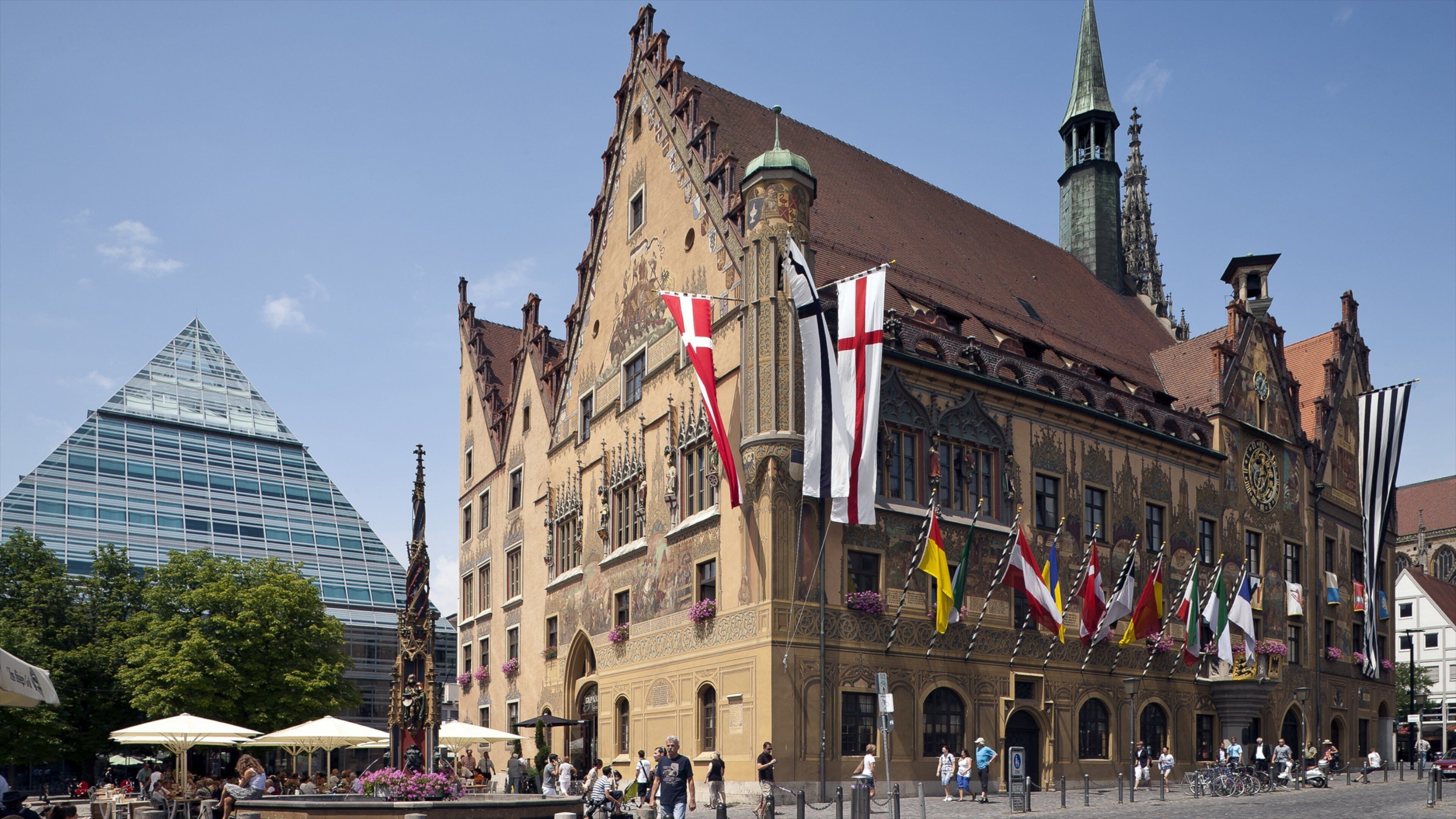 A historic building with ornate architecture and multiple flags.