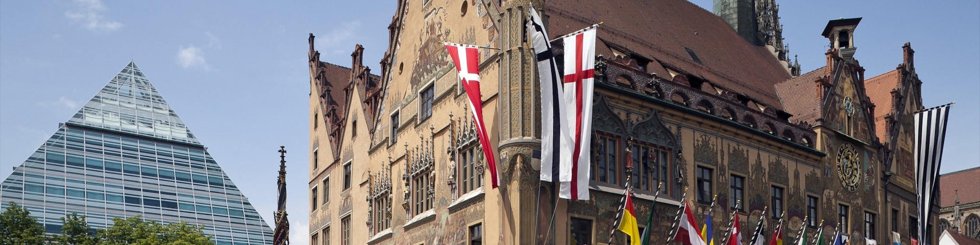 A historic building with ornate architecture and multiple flags.