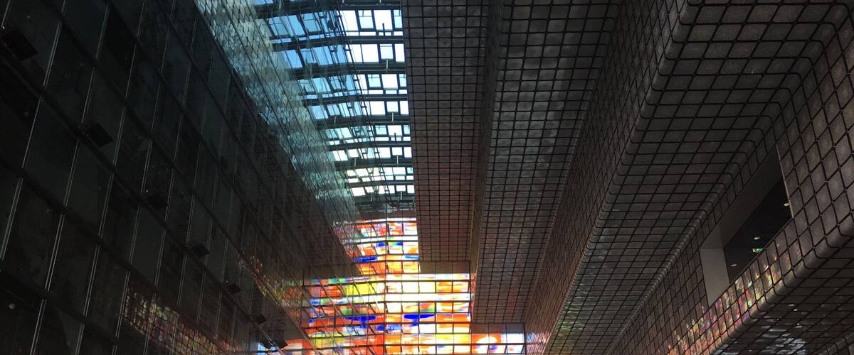 A modern building with a glass facade and colorful stained glass windows.