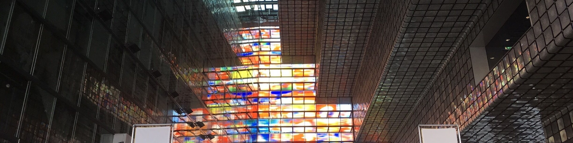A modern building with a glass facade and colorful stained glass windows.