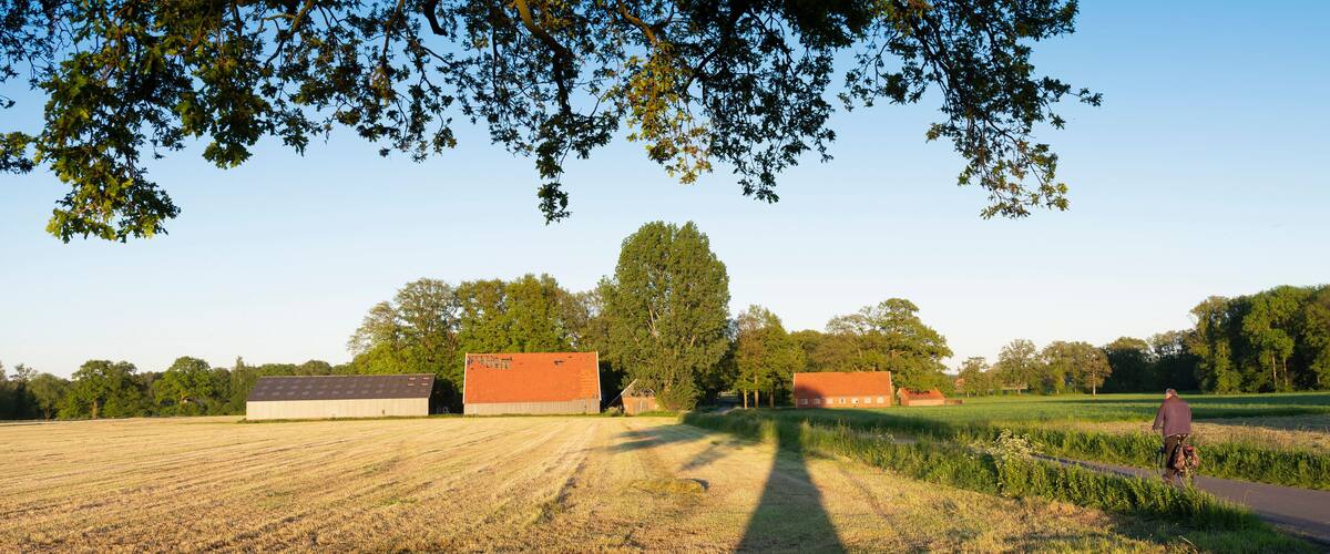 A rural landscape with fields, barns, and trees.