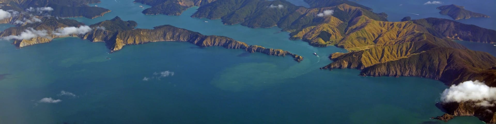 A mountainous landscape with multiple islands surrounded by turquoise waters.