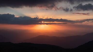 Sunset as viewed from Australia's highest mountain peak, Mt Kosciuszko. The Victorian high country can be seen in the distance.