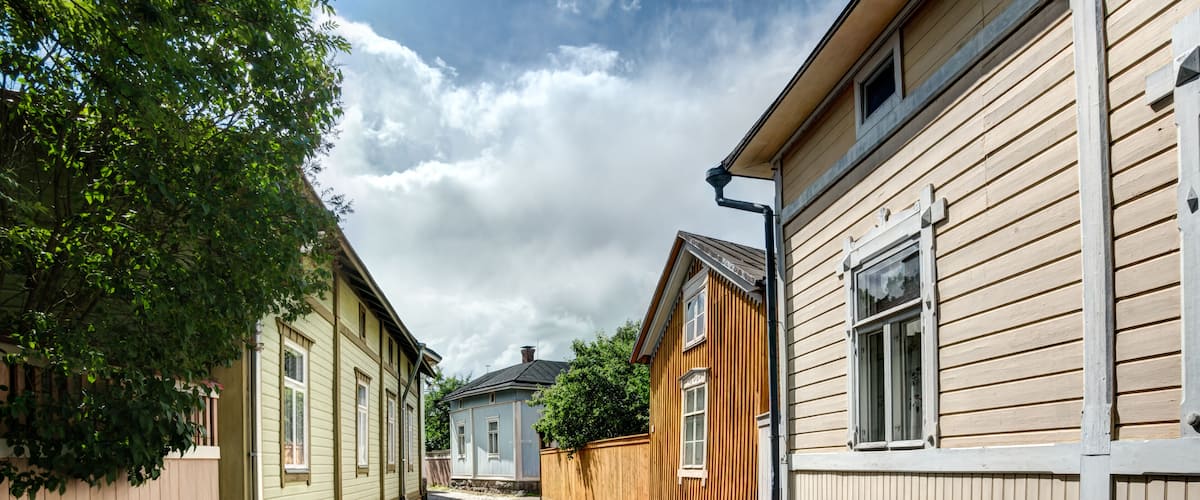 A cobblestone street flanked by wooden houses with a clear sky above.