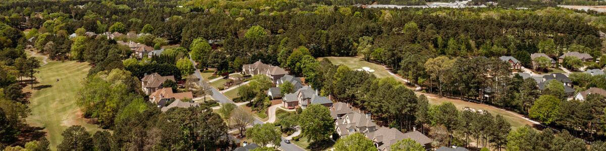 Aerial panoramic view of house cluster in a sub division in Suburbs with golf course and lake in metro Atlanta in Georgia ,USA shot by drone shot during golden hour