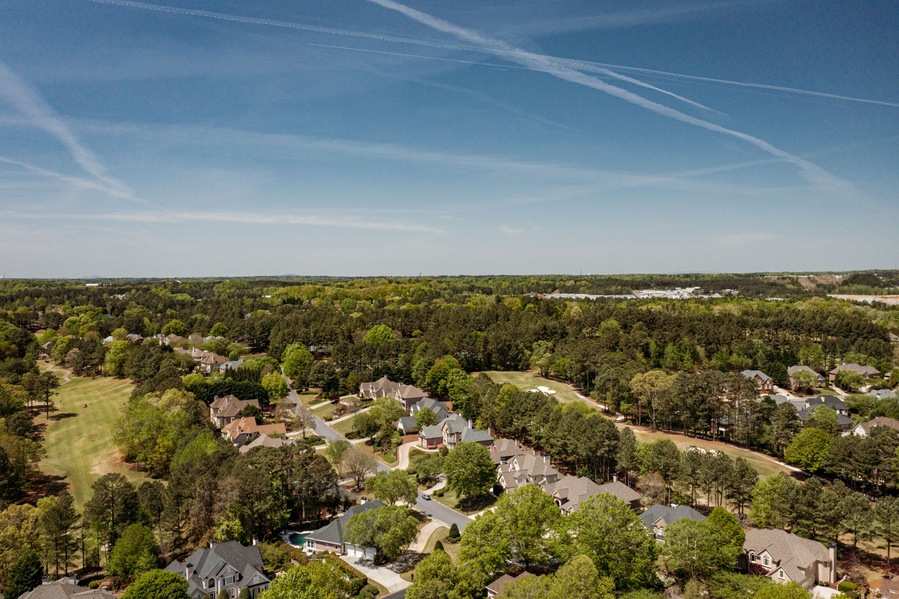 Aerial panoramic view of house cluster in a sub division in Suburbs with golf course and lake in metro Atlanta in Georgia ,USA shot by drone shot during golden hour