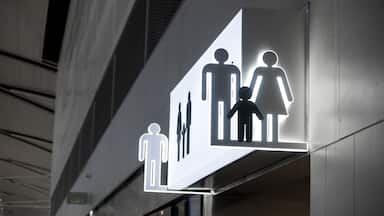 Un edificio moderno con señalización iluminada que presenta figuras humanas.