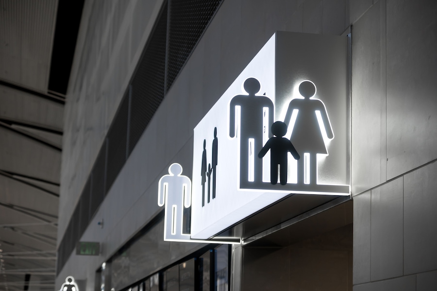 A modern building with illuminated signage featuring human figures.