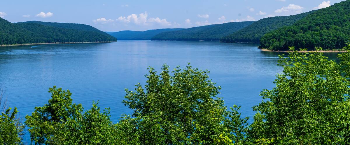 A calm lake surrounded by lush green hills.
