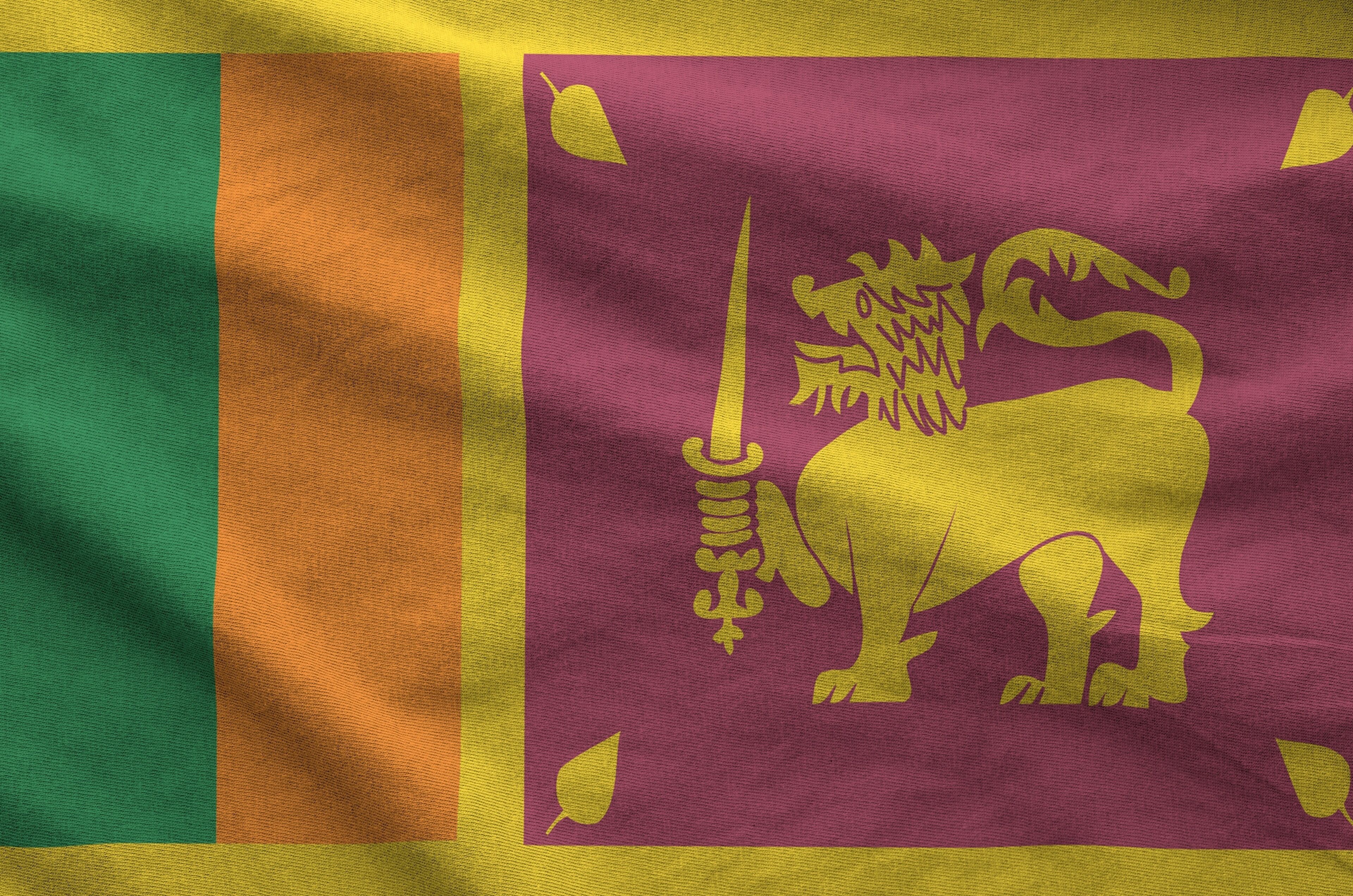 Sri Lanka flag depicted on folded wavy fabric of old cloth close up
