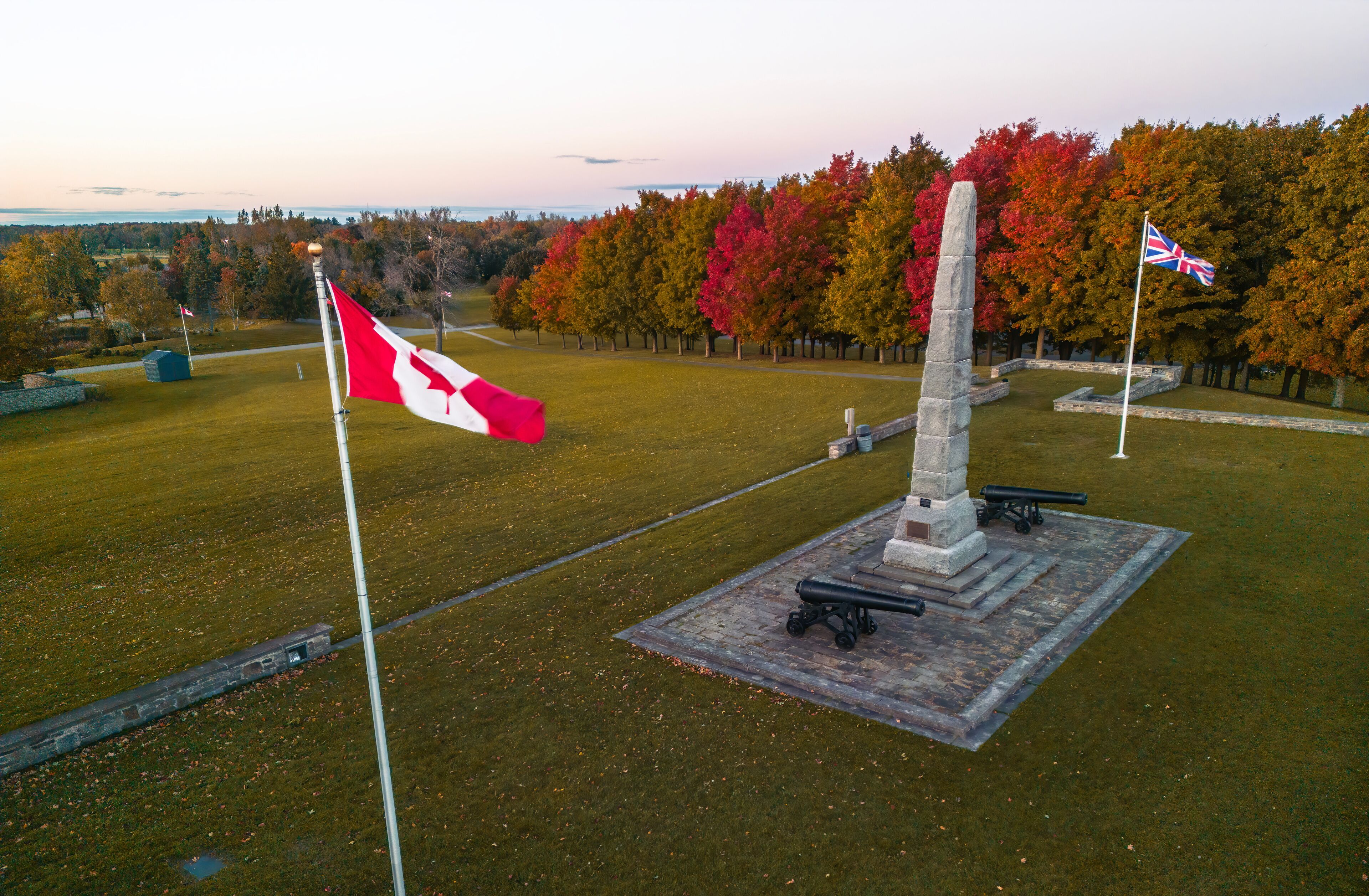 A memorial with a flagpole, a cannon, and a flag.