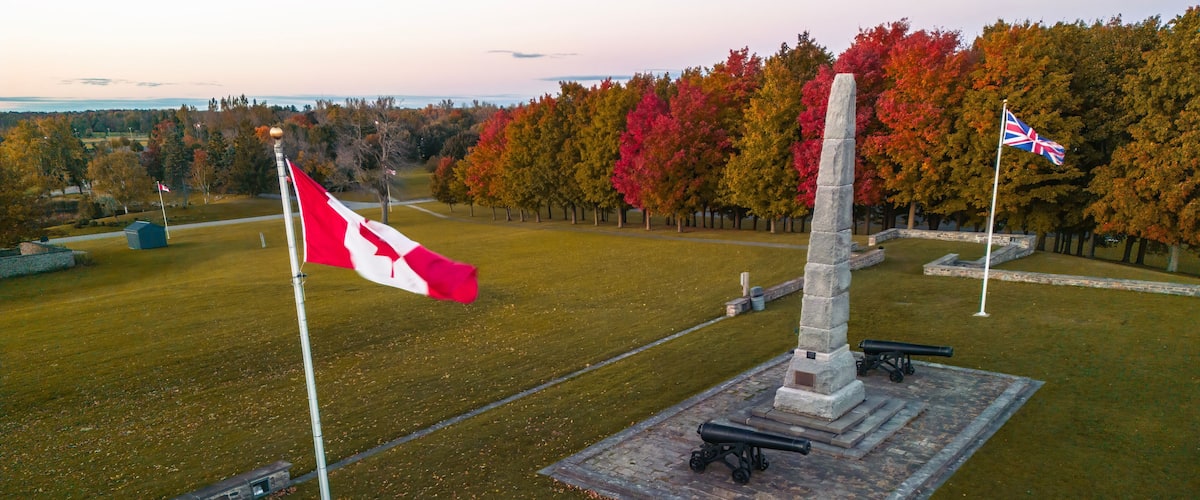 A memorial with a flagpole, a cannon, and a flag.