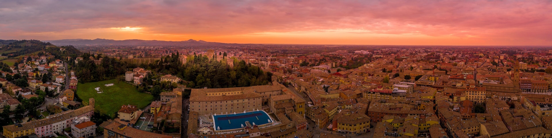 Sunset aerial panorama of Cesena in Emilia Romagna Italy near Forli and Rimini, with the medieval Malatestiana castle, Piazza del Popolo and Roman Catholic churches and cathedral on a winter afternoon