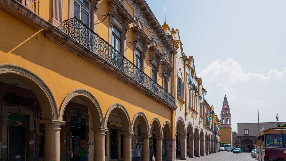A historic building with arched walkways and a clock tower.