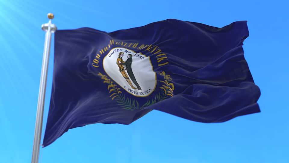 A flag with a white emblem featuring a woman and a man, surrounded by text and a laurel wreath.