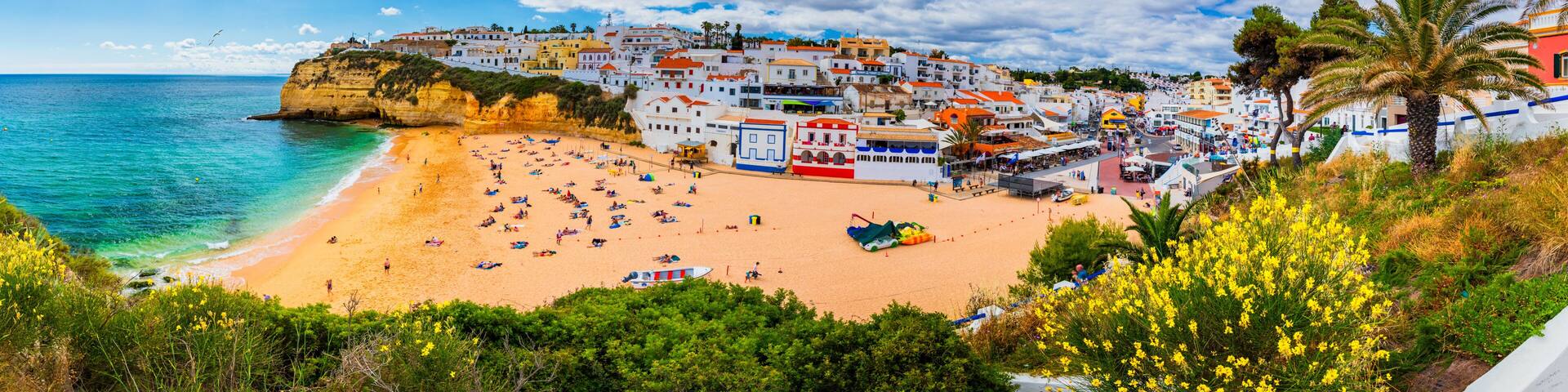 View of Carvoeiro fishing village with beautiful beach, Algarve, Portugal. View of beach in Carvoeiro town with colorful houses on coast of Portugal. The village Carvoeiro in the Algarve Portugal.