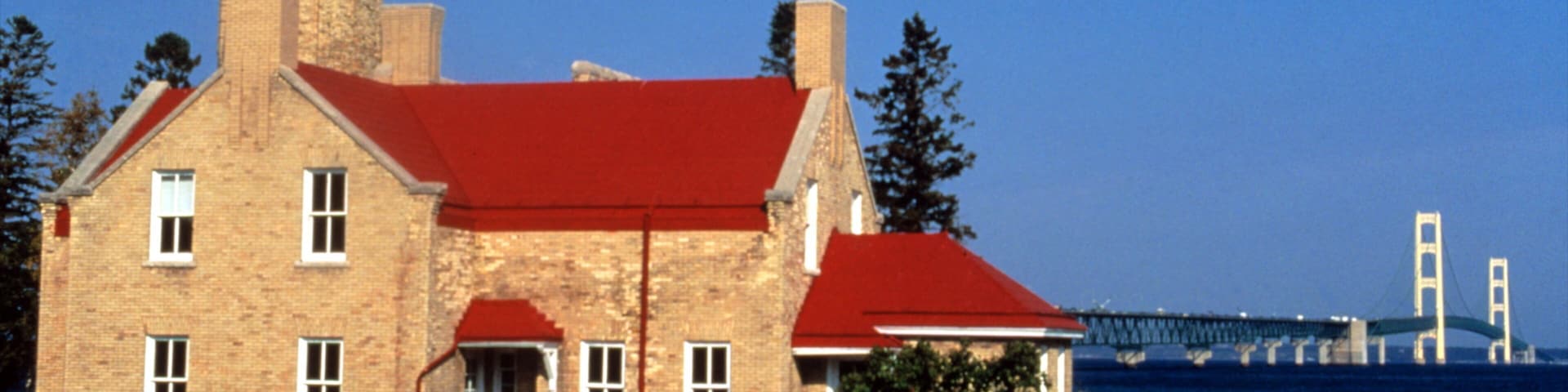 Mackinaw City ofreciendo arquitectura patrimonial, vista general a la costa y un faro