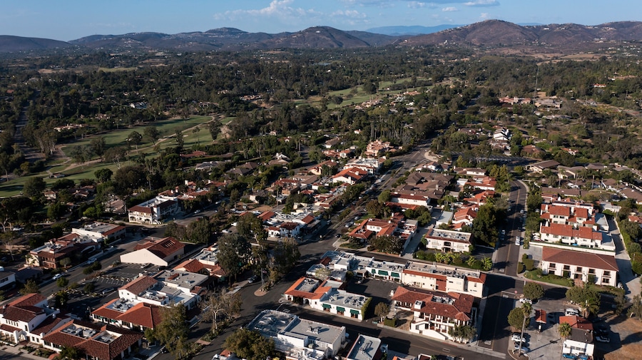 Afternoon aerial view of tree framed mission revival style architecture of historic downtown Rancho Santa Fe, California, USA.