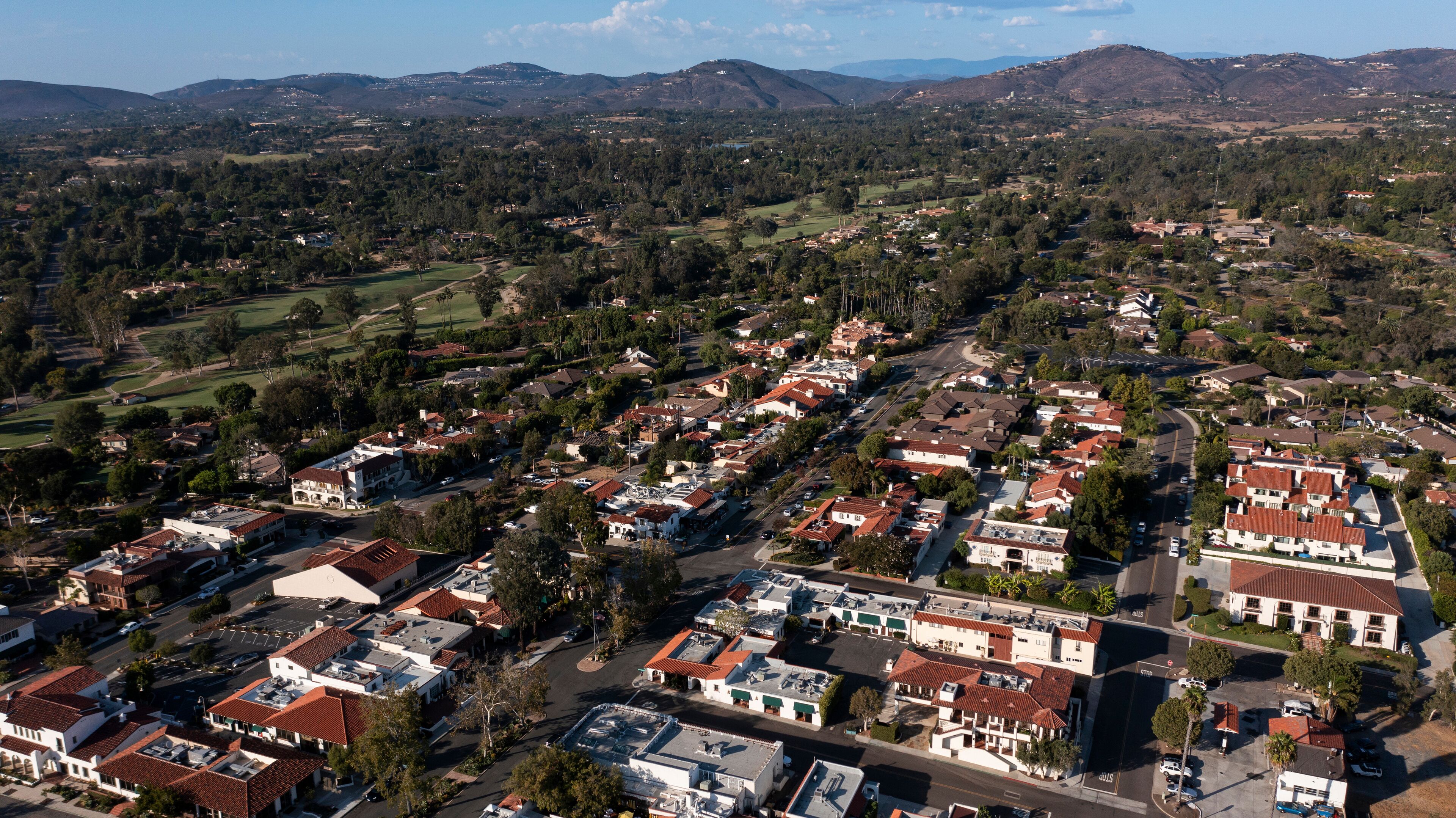 A residential area with houses, roads, and surrounding greenery.