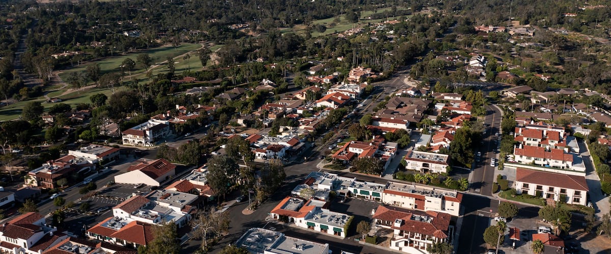 A residential area with houses, roads, and surrounding greenery.