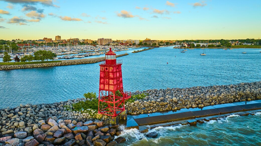 Aerial View of Vibrant Red Lighthouse at Sunset Over Calm Marina
