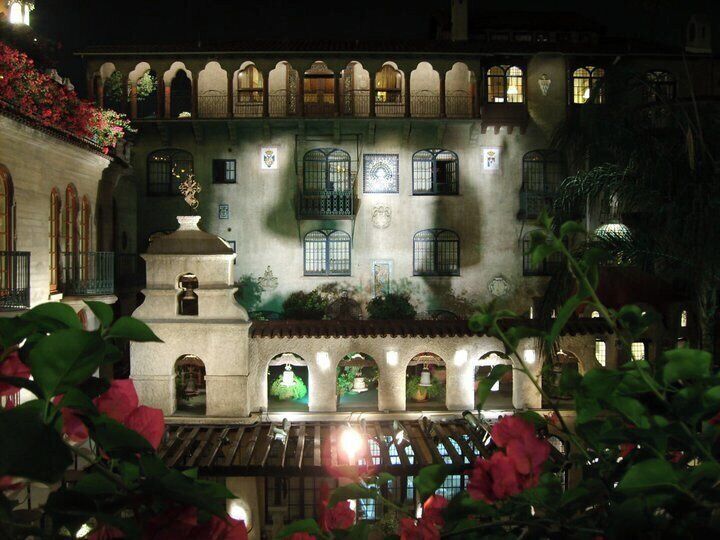 A historic building with arched windows and balconies, illuminated at night.